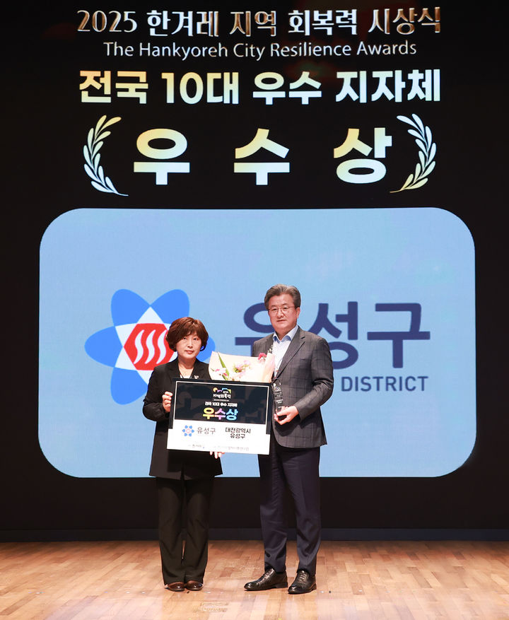 [대전=뉴시스] 조명휘 기자 = 정용래 대전 유성구청장이 지난 23일 서울 중구 대한상공회의소 국제회의장에서 열린 '2025 한겨레 지역 회복력 평가' 시상식에서 전국 10대 우수 지방자치단체에 선정돼 상패를 받고 있다. (사진= 유성구 제공) 2025.10.24. photo@newsis.com *재판매 및 DB 금지