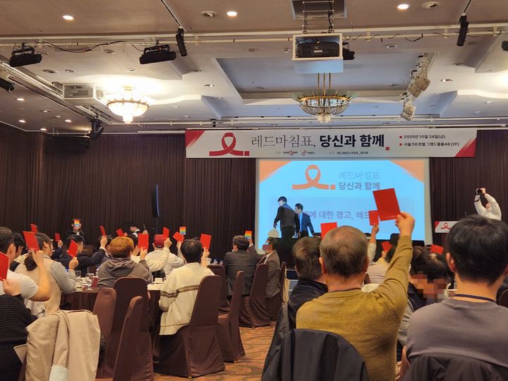[서울=뉴시스] 이승주 기자=지난 24일 '레드마침표, 당신과 함께!' 행사에서 HIV 감염인 등 참석자들이 '레드카드'를 들고 HIV 차별 종식 퍼포먼스를 하고 있다. 2025.10.26. heyjude@newsis.com *재판매 및 DB 금지