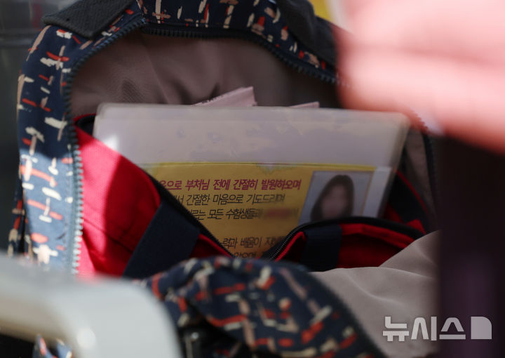 [서울=뉴시스] 조성우 기자 = 2026학년도 대학수학능력시험을 20일 앞둔 24일 오후 서울 종로구 조계사에서 학업성취 기원 화엄성중 기도가 진행 중인 가운데 한 신도 가방에 수능 고득점 기원 문구가 적힌 종이가 들어있다. 2025.10.24. xconfind@newsis.com