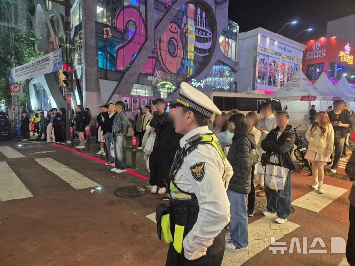 [서울=뉴시스] 이윤석 수습기자=핼러윈을 앞둔 25일 오후 서울 마포구 홍대입구역 인근. 경찰이 횡단보도 앞에서 시민들의 이동을 통제하고 있다. 2025.10.25. leeys@newsis.com