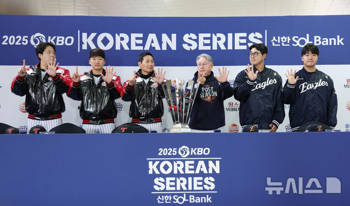 [서울=뉴시스] 김진아 기자 = 염경엽 LG 트윈스 감독과 김경문 한화 이글스 감독을 비롯한 선수들이 25일 서울 잠실야구장에서 열린 2025 KBO 한국시리즈 미디어데이에서 우승 트로피와 기념촬영을 하던 중 손가락으로 몇 차전 경기까지 갈 것인지 표시하고 있다. 왼쪽부터 LG 트윈스 임찬규, 박해민, 염 감독, 한화 이글스 김 감독, 채은성, 정우주. 2025.10.25. bluesoda@newsis.com