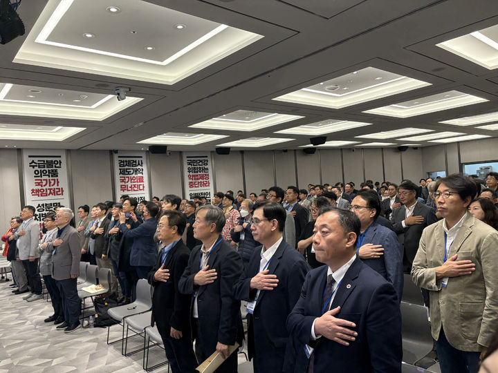 [서울=뉴시스] 정병혁 기자 = 25일 서울 용산구 대한의사협회에서 열린 대한의사협회 2025년도 긴급 임시대의원총회에서 참석자들이 국민의례를 하고 있다. (사진=대한의사협회 제공) 2025.10.25. photo@newsis.com *재판매 및 DB 금지
