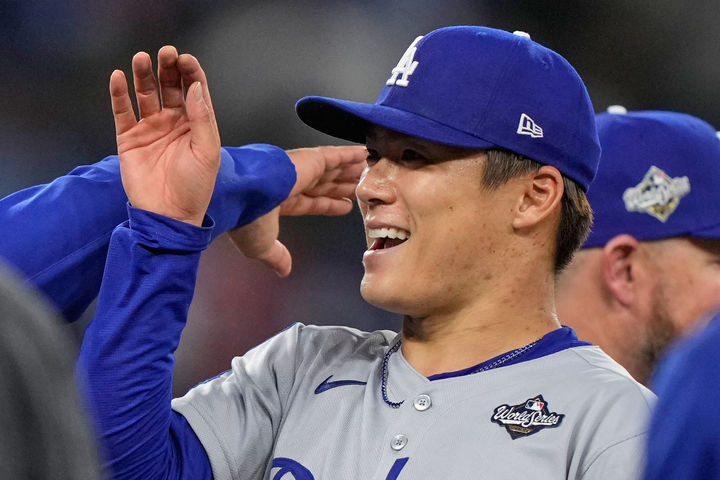 [토론토=AP/뉴시스]메이저리그(MLB) LA 다저스의 일본인 투수 야마모토 요시노부가 26일(한국 시간) 캐나다 온타리오주 토론토 로저스센터에서 열린 2025 MLB 포스트시즌(PS) 월드시리즈 2차전에서 완투승을 따낸 뒤 환하게 웃고 있다. 2025.10.26. 