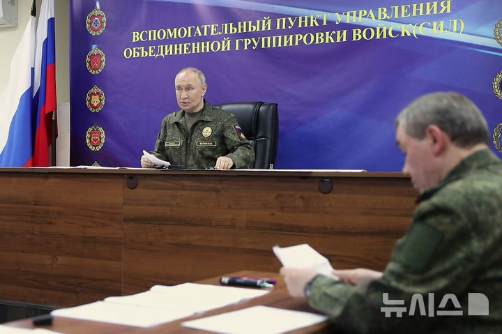 [AP/뉴시스] 26일 러시아 크렘린이 공개한 비디오 사진으로 위장 전투복 차림의 푸틴 대통령이 군 지휘소에서 게라시모프 총참모장의 보고를 받고 지시하고 있다. 게라시모프는 22일 새 순항미사일 부레베스트니크 테스트가 성공리에 실시되었다고 말했다. 