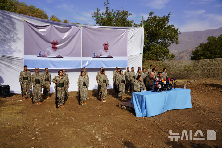 [AP/뉴시스] 튀르키예에서 무장해제를 했던 쿠르드노동자당 전투요원들이 26일 무기를 가지고 이라크 북부로 철수한 뒤 관련 행사 중 차렷 자세로 하고 있다