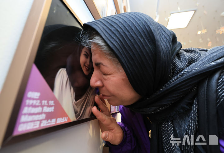 [서울=뉴시스] 김근수 기자 = 10·29 이태원참사 외국인 유가족이 26일 오후 서울 종로구 별들의 집에 방문해 희생자의 사진에 얼굴을 대고 있다. (공동취재) 2025.10.26. photo@newsis.com