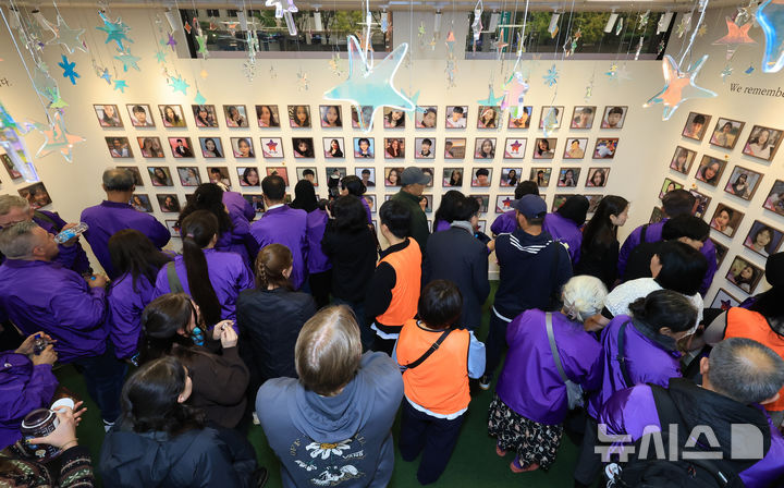 [서울=뉴시스] 김근수 기자 = 10·29 이태원참사 외국인 유가족들이 26일 오후 서울 종로구 별들의 집에 방문해 벽에 걸린 희생자의 사진을 살펴보고 있다. (공동취재) 2025.10.26. photo@newsis.com