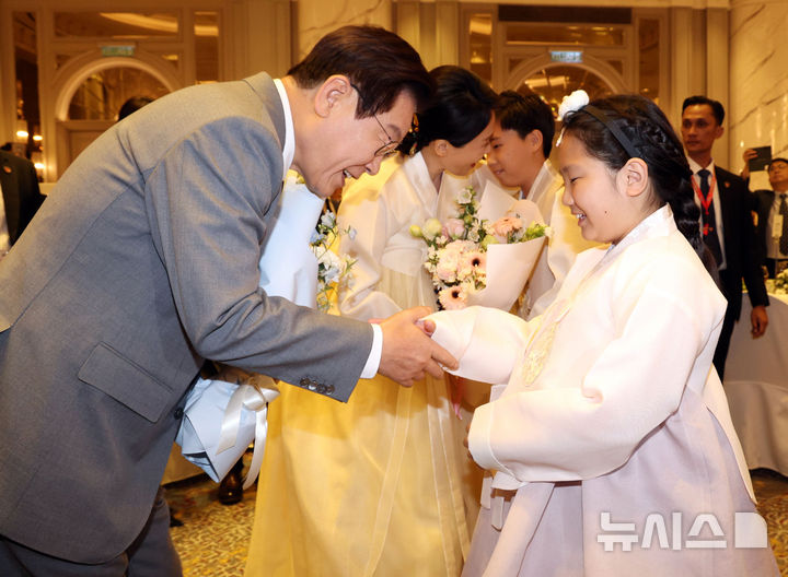 [쿠알라룸푸르=뉴시스] 고범준 기자 = 이재명 대통령과 김혜경 여사가 26일(현지 시간) 말레이시아 쿠알라룸푸르 한 호텔에서 열린 동포 간담회에서 화동에게 꽃다발을 받고 있다. 2025.10.26. bjko@newsis.com