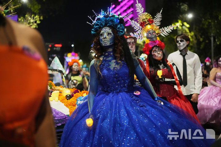 [멕시코시티=AP/뉴시스] 26일(현지 시간) 멕시코 수도 멕시코시티에서 해골 분장을 사람들이 연례 망자의 날 ‘카트리나 퍼레이드’에 참가하고 있다. '죽은 자들의 날'은 매년 10월 31일부터 11월 2일까지 죽은 이들을 기리는 멕시코 명절이다. 멕시코인들은 세상을 떠난 이들이 1년에 한 번 가족과 친구를 만나러 세상에 내려온다고 믿어 10월 말일에 제단을 마련한 뒤 11월 1일에는 죽은 아이들을, 11월 2일에는 죽은 어른들을 위해 기도를 올린다. 2025.10.27.