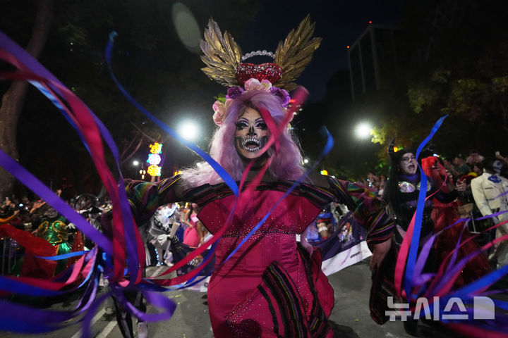 [멕시코시티=AP/뉴시스] 26일(현지 시간) 멕시코 수도 멕시코시티에서 해골 분장을 사람들이 연례 망자의 날 ‘카트리나 퍼레이드’에 참가하고 있다. '죽은 자들의 날'은 매년 10월 31일부터 11월 2일까지 죽은 이들을 기리는 멕시코 명절이다. 멕시코인들은 세상을 떠난 이들이 1년에 한 번 가족과 친구를 만나러 세상에 내려온다고 믿어 10월 말일에 제단을 마련한 뒤 11월 1일에는 죽은 아이들을, 11월 2일에는 죽은 어른들을 위해 기도를 올린다. 2025.10.27.