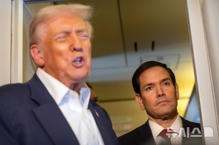 [AP/뉴시스] 트럼프 대통령이 일본으로 향하는 에어포스원 비행기 안에서 동행 취재기자 실 앞에서 질문에 답하고 있다. 옆에 루비오 국무장관이 서 있다. 트럼프는 다른 대통령과 달리 스스로 기자실로 와서 먼저 말문을 여는 것으로 유명하다.