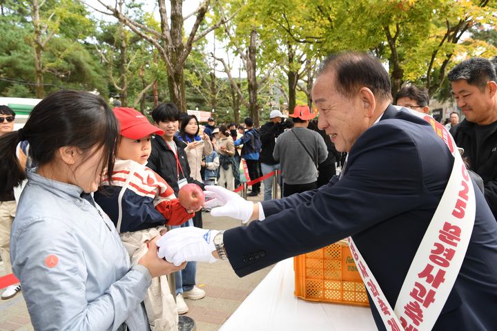 [문경=뉴시스] 신현국 문경시장이 '문경사과축제'에서 방문객들에게 감홍사과를 나눠주고 있다. (사진=문경시 제공) 2025.10.27. photo@newsis.com *재판매 및 DB 금지