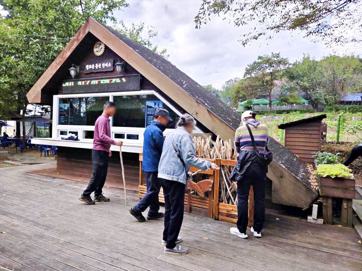 [수원=뉴시스] 등산객들이 광교산 등산 안내소 앞에 있는 지팡이를 고르고 있다.. (사진=수원시 제공) 2025.10.27. photo@newsis.com *재판매 및 DB 금지