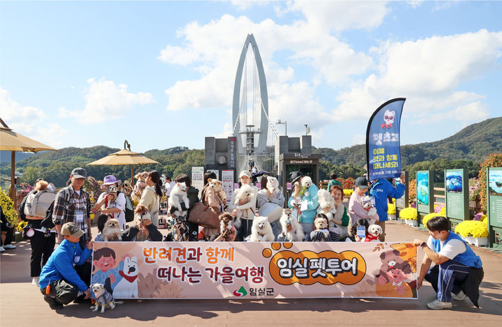 [임실=뉴시스] 지난 24일 1차 '임실 펫투어' 참가자들이 반려동물과 함께 옥정호 출렁다리 앞에서 기념사진을 찍고 있다. *재판매 및 DB 금지