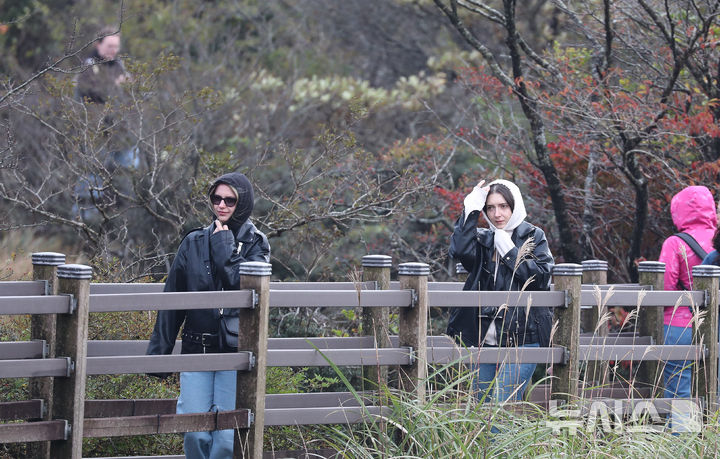 [제주=뉴시스] 우장호 기자 = 바람이 불어 쌀쌀한 날씨를 보인 27일 오전 제주 한라산 1100고지 습지에서 두툼한 옷차림을 한 외국인 관광객들이 추위를 피해 이동하고 있다. (사진=뉴시스DB) woo1223@newsis.com
