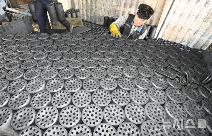 [화성=뉴시스] 김종택 기자 = 초겨울 날씨를 보인 27일 경기 화성시 배양동 한 연탄 출하장에서 관계자들이 분주하게 연탄을 트럭으로 옮기고 있다. 2025.10.27. jtk@newsis.com