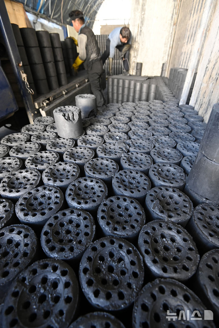 [화성=뉴시스] 김종택 기자 = 초겨울 날씨를 보인 27일 경기 화성시 배양동 한 연탄 출하장에서 관계자들이 분주하게 연탄을 트럭으로 옮기고 있다. 2025.10.27. jtk@newsis.com