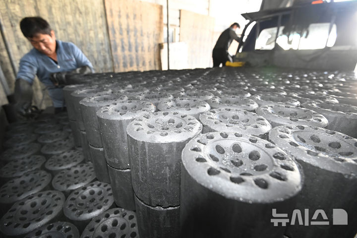 [화성=뉴시스] 김종택 기자 = 초겨울 날씨를 보인 27일 경기 화성시 배양동 한 연탄 출하장에서 관계자들이 분주하게 연탄을 트럭으로 옮기고 있다. 2025.10.27. jtk@newsis.com