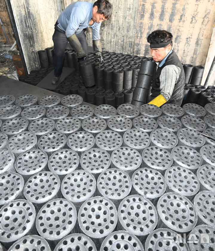 [화성=뉴시스] 김종택 기자 = 초겨울 날씨를 보인 27일 경기 화성시 배양동 한 연탄 출하장에서 관계자들이 분주하게 연탄을 트럭으로 옮기고 있다. 2025.10.27. jtk@newsis.com