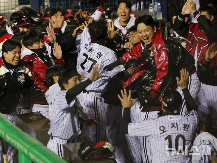[서울=뉴시스] 홍효식 기자 = 27일 오후 서울 송파구 잠실야구장에서 열린 2025 KBO 한국시리즈 2차전 한화 이글스와 LG 트윈스의 경기, 2회말 무사 2,3루 LG 구본혁의 1루타때 홈인한 박동원과 오지환이 더그아웃에서 동료들과 기뻐하고 있다. 2025.10.27. yesphoto@newsis.com