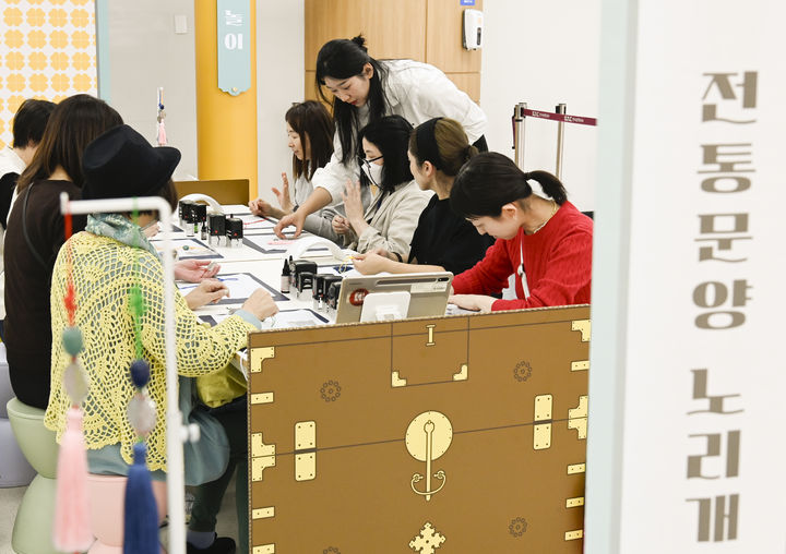 [서울=뉴시스] 27일 김포공항 국제선 터미널에서 열린 전통문화 체험행사에서 공항 이용객이 노리개 만들기 체험에 참여하고 있다. 2025.10.28. (사진=한국공항공사 제공) photo@newsis.com *재판매 및 DB 금지