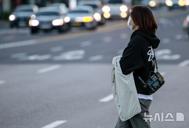 [서울=뉴시스] 정병혁 기자 = 추운 날씨가 이어진 28일 서울 종로구 광화문네거리에서 한 시민이 옷으로 손을 감싼 채 이동하고 있다. 2025.10.28. jhope@newsis.com