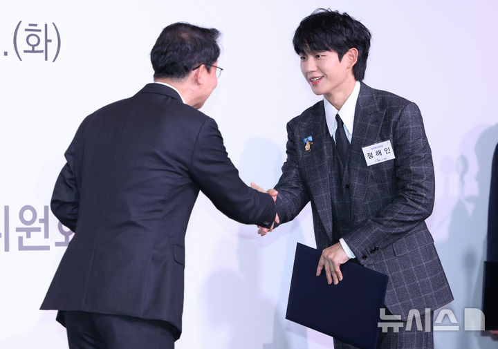 [서울=뉴시스] 황준선 기자 = 배우 정해인이 28일 오전 서울 여의도 FKI타워에서 열린 제10회 금융의 날 기념식에서 이억원 금융위원장에게 국무총리 표창을 수상하고 있다. 2025.10.28. hwang@newsis.com