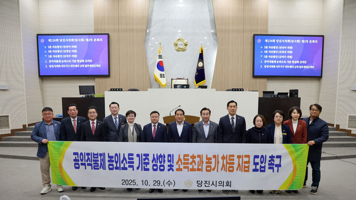 [서산=뉴시스] 충남 당진시의회 의원들이 29일 시의회 본회의장에서 김덕주 의원이 대표 발의한 '공익직불제 농외소득 기준 현실화 촉구 건의안'을 채택한 후 기념 사진을 찍고 있다. (사진=당진시의회 제공) 2025.10.29. photo@newsis.com *재판매 및 DB 금지