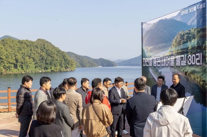 [대전=뉴시스] 조명휘 기자 = 최충규(가운데) 대전 대덕구청장과 대덕구 명예구청장, 주민들이 29일 미호동 산61번지 일원에서 ‘대청호 생태 탐방로 조성사업’ 사업대상지를 점검하고 있다. (사진= 대덕구 제공) 2025.10.29. photo@newsis.com *재판매 및 DB 금지