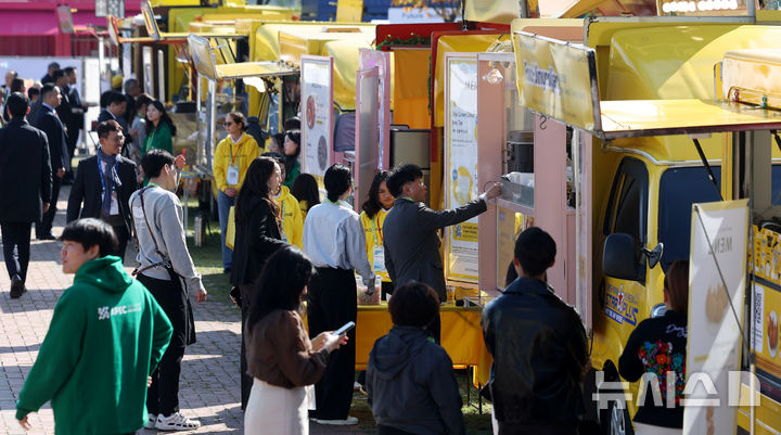 [경주=뉴시스] 추상철 기자 = 아시아태평양경제협력체(APEC) CEO 써밋이 열린 29일 경북 경주예술의전당 앞에 마련된 'KB 푸드트럭 파크' K-푸드 체험존에서 국내외 참가자들이 무료로 제공되는 음식을 시식하기 위해 길게 줄 서 있다. 2025.10.29. scchoo@newsis.com