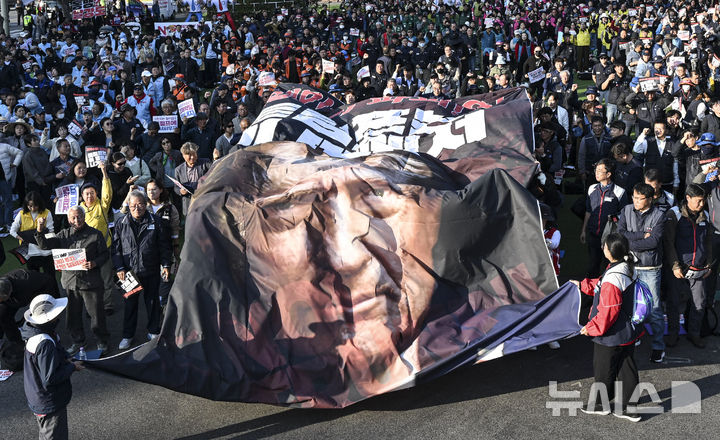 [서울=뉴시스] 이무열 기자 = 29일 경북 경주시 (구)경주역 광장에서 열린 트럼프 방한 반대 민주노총 결의대회에서 참가자들이 대형 현수막을 찢는 퍼포먼스를 하고 있다. (공동취재) 2025.10.29. photo@newsis.com