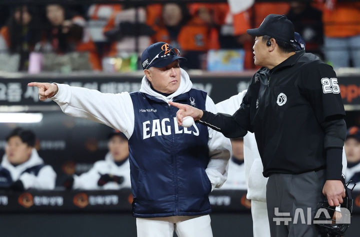 [대전=뉴시스] 조성우 기자 = 29일 대전 중구 한화생명볼파크에서 열린 2025 KBO 한국시리즈 3차전 LG 트윈스와 한화 이글스의 경기, 한화 2회말 공격 1사 주자 1, 2루서 이도윤의 내야 뜬공 때 LG 유격수 오지환이 고의 낙구 후 병살로 이닝이 끝내자 김경문 한화 감독이 그라운드에 나와 심판에게 항의하고 있다. 2025.10.29. xconfind@newsis.com