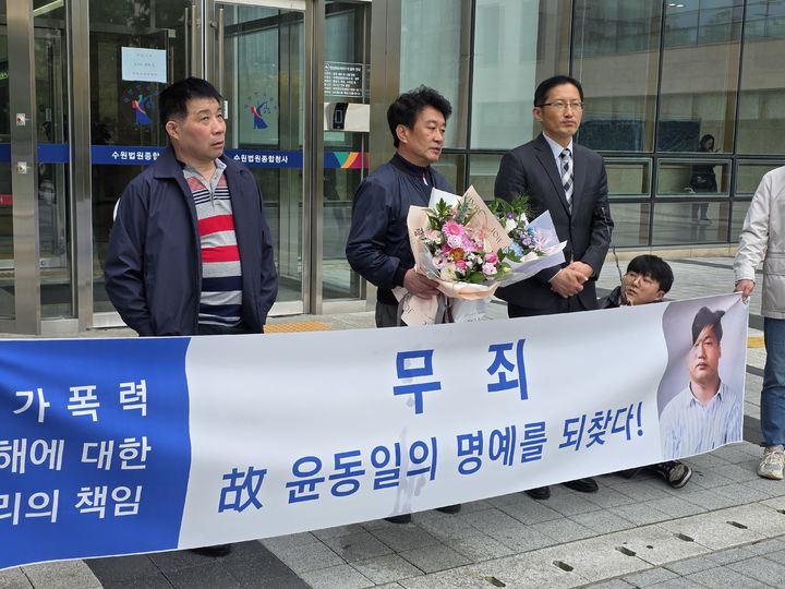 [수원=뉴시스] 변근아 기자= 이춘재 연쇄살인 용의자로 몰렸던 故윤동일씨의 친형이(사진 왼쪽에서 두번째)가 30일 재심 재판 선고 직후 법원 앞에서 기자회견을 하고 있다. 2025.10.30. gaga.99@daum.net *재판매 및 DB 금지