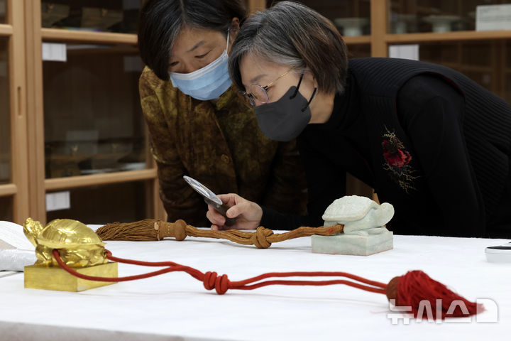 [서울=뉴시스] 박진희 기자 = 국립고궁박물관 수장고 속 왕실 유산 심층조사가 열린 30일 서울 종로구 국립고궁박물관 열린수장고에서 박선경 매듭장 전승교육사와 박선희 매듭장 이수자가 1667년 제작한 '숙종 왕세자책봉 옥인'을 심층조사 하고 있다. 2025.10.232025.10.00. pak7130@newsis.com