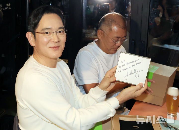 [서울=뉴시스] 정병혁 기자 = 이재용 삼성전자 회장이 30일 서울 강남구 삼성역 깐부치킨 매장에서 정의선 현대차그룹 회장, 젠슨 황 엔비디아 최고경영자(CEO)와 치킨 회동 중 받은 선물을 취재진에게 보이고 있다. (공동취재) 2025.10.30. photo@newsis.com