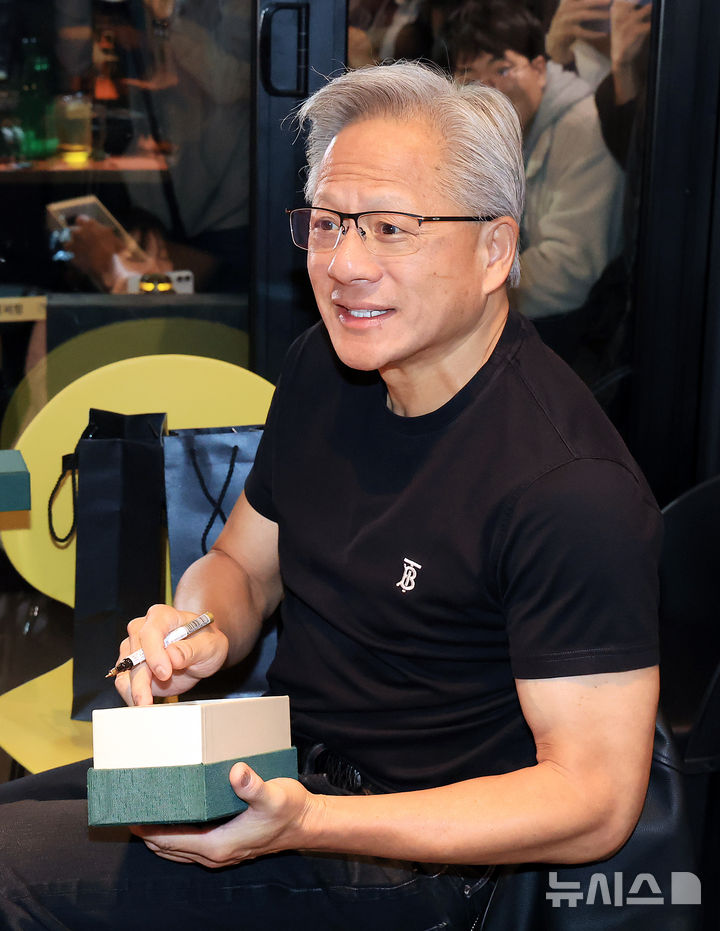 [서울=뉴시스] 정병혁 기자 = 젠슨 황 엔비디아 최고경영자(CEO)가 30일 서울 강남구 삼성역 깐부치킨 매장에서 이재용 삼성전자 회장, 정의선 현대차그룹 회장과의 치맥 회동 중 선물에 사인하고 있다. (공동취재) 2025.10.30. photo@newsis.com