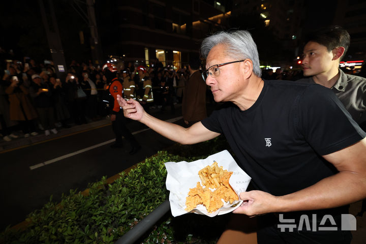 [서울=뉴시스] 정병혁 기자 = 젠슨 황 엔비디아 최고경영자가 30일 이재용 삼성전자 회장, 정의선 현대자동차그룹 회장과 서울 강남구 깐부치킨 매장에서 치킨 회동 중 밖으로 나와 시민들에게 치킨 등을 나눠주고 있다. (공동취재) 2025.10.30. photo@newsis.com