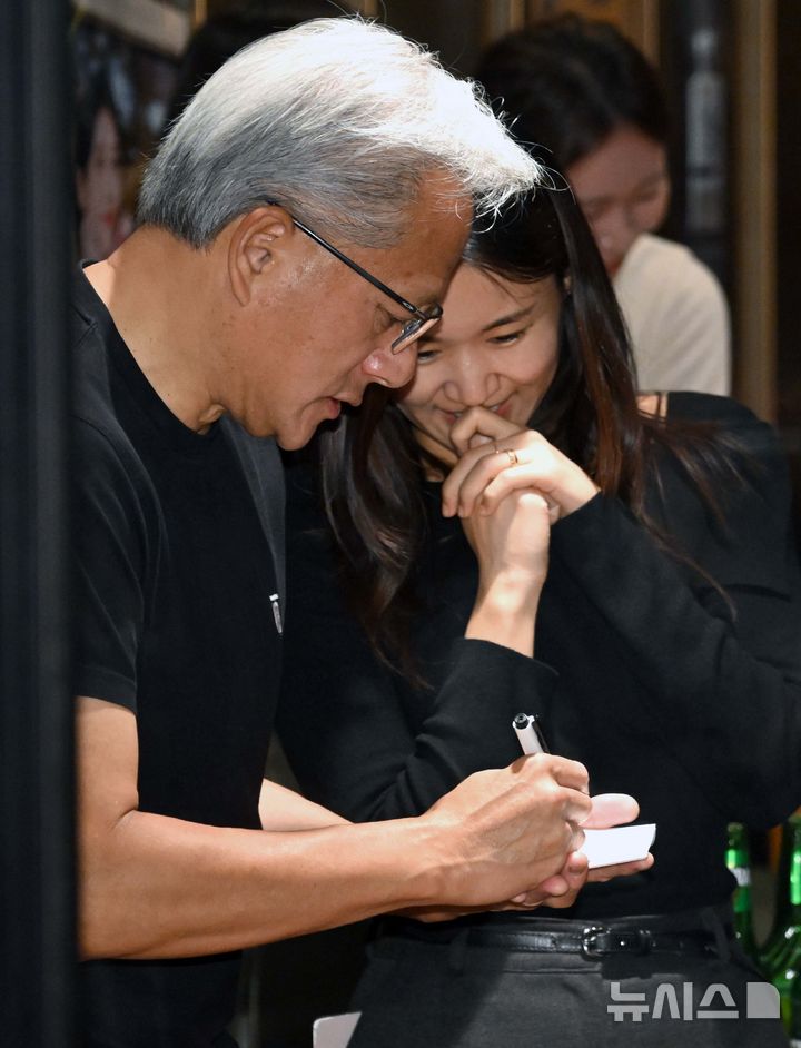 [서울=뉴시스] 정병혁 기자 = 젠슨 황 엔비디아 최고경영자(CEO)가 30일 오후 서울 강남구 삼성역 인근 깐부치킨 매장에서 이재용 삼성그룹 회장, 정의선 현대차그룹 회장과 치킨 회동 중 시민들에게 사인을 해주고 있다. (공동취재) 2025.10.30. photo@newsis.com