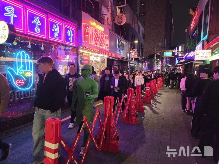 [서울=뉴시스]김윤영 수습기자 =31일 오후 서울 용산구 이태원 세계음식문화거리. 핼러윈을 맞아 분장을 한 시민들이 붉은 펜스가 세워진 골목을 따라 이동하고 있다. 2025.10.31