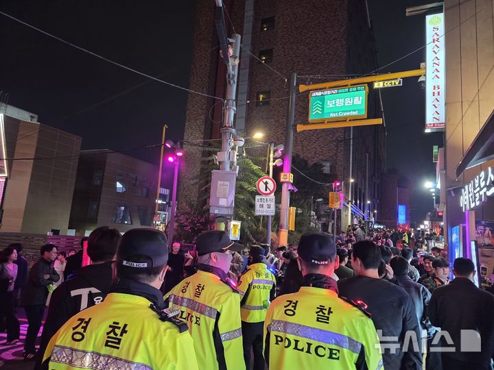 [서울=뉴시스]김윤영 수습기자=31일 오후 서울 용산구 이태원 해밀톤호텔 인근 거리. 경찰이 붉은 펜스가 설치된 골목에서 순찰하며 인파를 통제하고 있다. 상단 전광판에는 '보행 원활' 문구가 표시돼 있다.