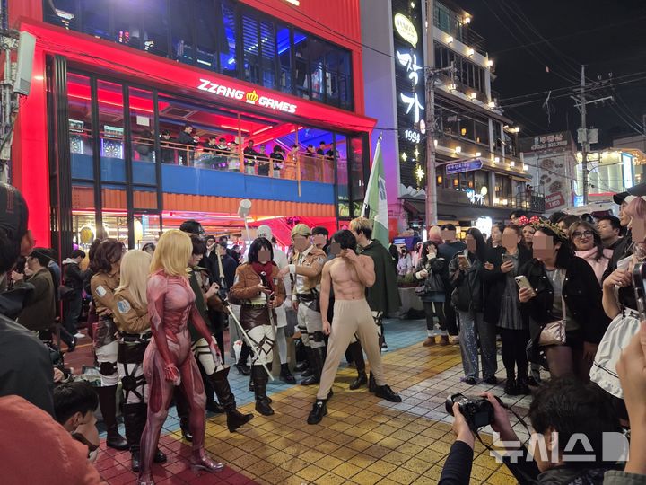 [서울=뉴시스]김윤영 수습기자=31일 밤 서울 마포구 홍대 레드로드 일대에서 애니메이션 '진격의 거인' 등장인물로 분장한 시민들이 퍼포먼스를 선보이고 있다. 핼러윈을 맞아 홍대 거리는 다양한 코스튬을 한 인파로 붐볐다. 2025.10.31.