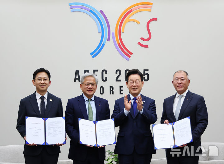 [경주=뉴시스] 고범준 기자 = 이재명 대통령이 31일 APEC 정상회의 장소인 경북 경주화백컨벤션센터(HICO)에서 젠슨 황 엔비디아 최고경영자(CEO) 접견에 앞서 과학기술정보통신부와 현대차, 엔비디아의 국내 피지컬 AI 역량 고도화 협약과 관련해 협악서를 들고 기념촬영을 하고 있다.  왼쪽부터 배경훈 부총리 겸 과학기술정보통신부 장관, 젠슨 황 엔비디아 최고경영자(CEO), 이재명 대통령, 정의선 현대차그룹 회장. (대통령실통신사진기자단) 2025.10.31. bjko@newsis.com