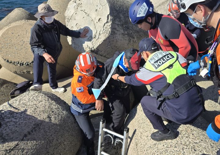 [울산=뉴시스] 울산해양경찰서와 울산소방본부 관계자들이 1일 오전 울산 동구 방어진 슬도 방파제 인근에서 테트라포드 사이로 추락한 60대 남성을 구조하고 있다. (사진=울산해양경찰서 제공) 2025.11.01. photo@newsis.com *재판매 및 DB 금지
