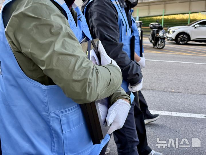 [서울=뉴시스] 한이재 기자 = 1일 오후 서울 용산구 일대에서 12.29 무안공항 제주항공 여객기 참사 유가족 협의회가 주관한 300일 진상규명 촉구 집회에서 한 유가족이 영정을 품에 안고 걷고 있다. 2025.11.01. nowone@newsis.com