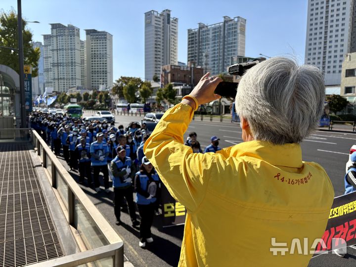 [서울=뉴시스] 한이재 기자 = 1일 오후 서울 용산구 일대에서 12.29 무안공항 제주항공 여객기 참사 유가족 협의회의 침묵 행진을 세월호 참사 유가족이 촬영하는 모습이 보이고 있다. 2025.11.01. nowone@newsis.com