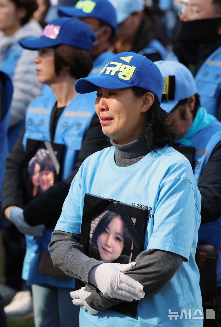 [서울=뉴시스] 조성우 기자 = 12·29 여객기 참사 유가족이 1일 오후 서울 용산구 용산역 앞에서 영정을 들고 여객기 추락 참사에 대한 진상규명과 책임자 처벌을 촉구하는 행진을 기다리다 울먹이고 있다. 2025.11.01. xconfind@newsis.com