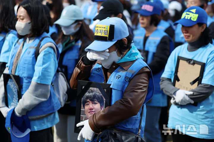 [서울=뉴시스] 조성우 기자 = 12·29 여객기 참사 유가족이 1일 오후 서울 용산구 용산역 앞에서 영정을 들고 여객기 추락 참사에 대한 진상규명과 책임자 처벌을 촉구하는 행진을 기다리다 눈물을 훔치고 있다. 2025.11.01. xconfind@newsis.com