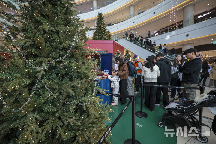[서울=뉴시스] 정병혁 기자 = 2일 서울 영등포구 타임스퀘어에 설치된 대형 크리스마스 트리를 찾은 시민들이 가챠이벤트에 참가하기 위해 줄 서 있다. 복합쇼핑몰 경방 타임스퀘어는 올해 'Merry & Bright'를 테마로 자체 캐릭터 '탐스프렌즈'와 협업해 꾸며진 13m의 초대형 크리스마스 트리를 공개했다. 2025.11.02. jhope@newsis.com
