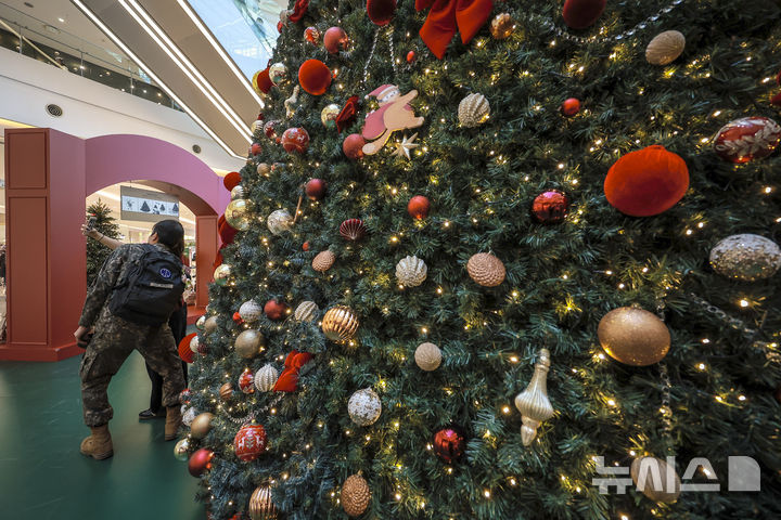 [서울=뉴시스] 정병혁 기자 = 2일 서울 영등포구 타임스퀘어에 설치된 대형 크리스마스 트리를 찾은 시민들이 사진을 찍으며 즐거운 시간을 보내고 있다.&nbsp; 복합쇼핑몰 경방 타임스퀘어는 올해 'Merry & Bright'를 테마로 자체 캐릭터 '탐스프렌즈'와 협업해 꾸며진 13m의 초대형 크리스마스 트리를 공개했다. 2025.11.02. jhope@newsis.com
