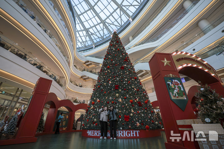 [서울=뉴시스] 정병혁 기자 = 2일 서울 영등포구 타임스퀘어에 설치된 대형 크리스마스 트리를 찾은 시민들이 사진을 찍으며 즐거운 시간을 보내고 있다.&nbsp; 복합쇼핑몰 경방 타임스퀘어는 올해 'Merry & Bright'를 테마로 자체 캐릭터 '탐스프렌즈'와 협업해 꾸며진 13m의 초대형 크리스마스 트리를 공개했다. 2025.11.02. jhope@newsis.com